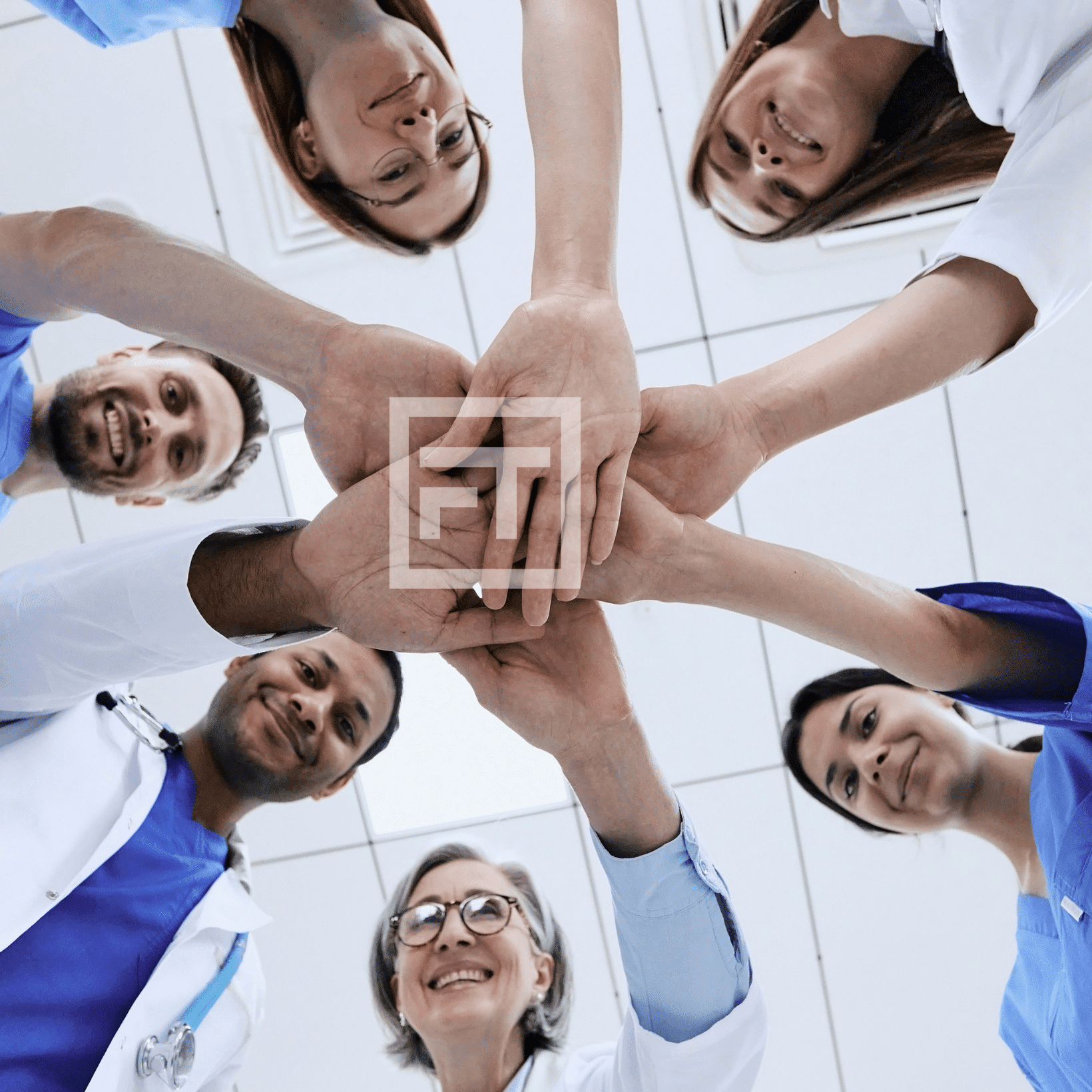 A medical team happy and doing a group huddle.